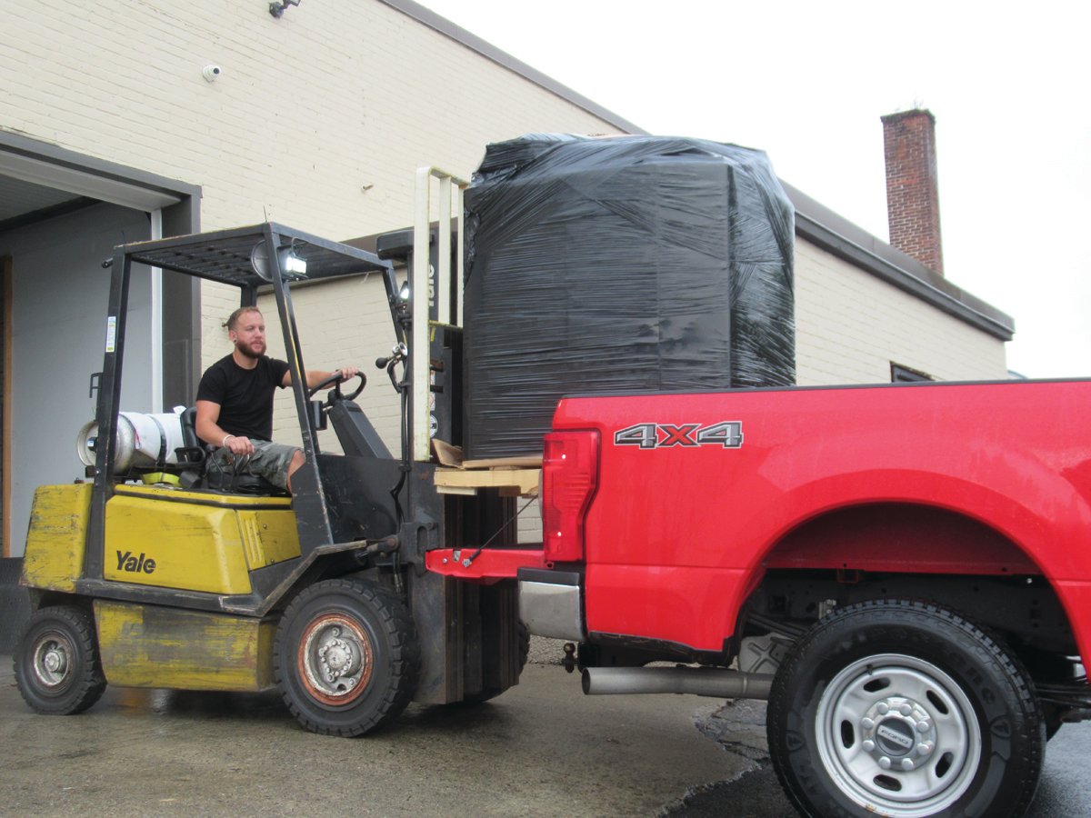 DELIGHTFUL DUTY: Steven Day Jr. uses a forklift to load a plastic-wrapped wooden palette containing more than 150 children’s games and more that will make Christmas 2022 merry for some little girls and boys in Johnston.